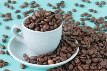 Coffee cup and beans on a aquamarine background.
