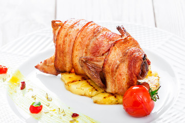 Roasted Pork steak on bone stuffed with cheese, grilled vegetables and berries on stone slate background on wooden background close up. Hot Meat Dishes. Top view with copy space