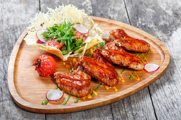 Roasted Pork steak on bone stuffed with cheese, grilled vegetables and berries on stone slate background on wooden background close up. Hot Meat Dishes. Top view with copy space