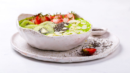 Breakfast Detox Green Smoothie  Bowl with fresh berries,kiwi and chia seeds. Food or Healthy diet concepton a white background.Super Food.selective focus.