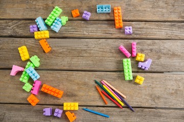 Overhead view of toy blocks with crayons on table