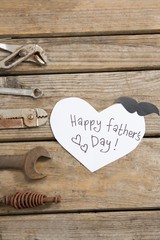Overhead view of happy fathers day text by hand tools on table
