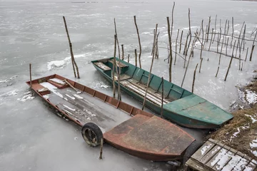 Zelfklevend Fotobehang Two old wooden boat, one wrecked in a frozen river Tisa near Becej, Serbia. Winter time © Simic Vojislav