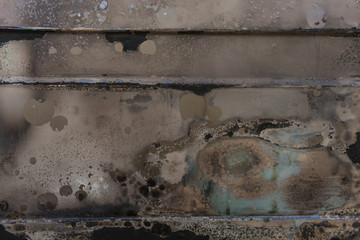 burnt corrugated lacquer colors on rusty metal surface, dull beige