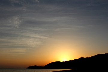 Fototapeta premium 沈みゆく夕陽と彩雲 The sunset in which I sink and beautifully colored cloud.