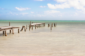 Destroyed wooden pier dock and picturesque, relaxing ocean view at Caye Caulker Belize Caribbean.