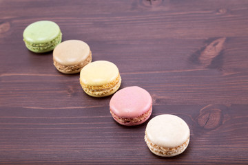  Tasty and colorful macarons on a natural ipe wood dark brown table