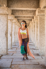 A young woman stands between the columns