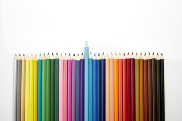 Many different colored pencils on white background