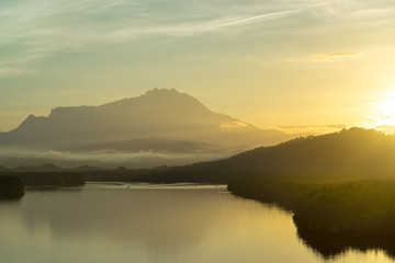 Fototapeta na wymiar Beautiful sunrise over Mount Kinabalu and river Ganyang in Sabah, Malaysia. View point from Mengkabong bridge