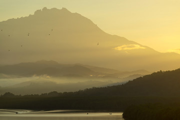 Beautiful sunrise over Mount Kinabalu and river Ganyang in Sabah, Malaysia. View point from Mengkabong bridge