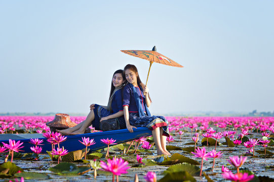 Laos woman in flower lotus lake, Woman wearing traditional Thai people , Red Lotus Sea UdonThani Thailand