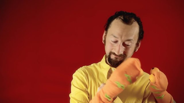 A funny man playing with two handmade sock puppets bickering and fighting.
