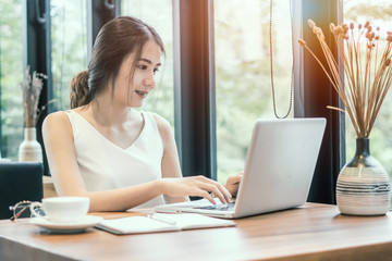 Fototapeta premium Young woman using laptop computer. Female working on laptop in a coffee shop.