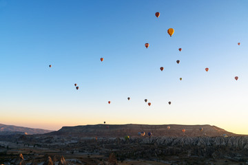 Hot air balloons flying over valley at sunrise. Cappadocia. Turkey