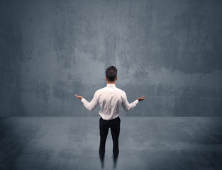 Businessman standing in front of urban wall