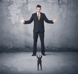 Obraz premium Big business bully looking at small coworker