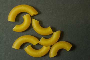 Macro of pieces of pasta isolated on dark background