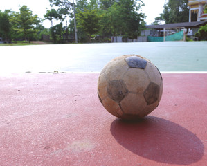 Old futsal ball on red field, old futsal ball is placed on red field 