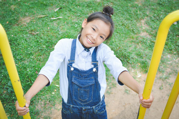 Asian girl playing in playground happy on holiday selective and soft focus