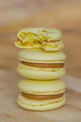 french cookies yellow macaroons on a wood background
