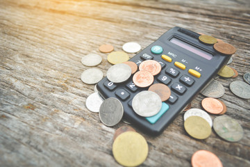 Close up calculator and coin on wood background