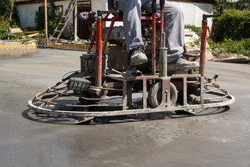 Naklejka premium Working ride on power trowel machine on a concrete slab