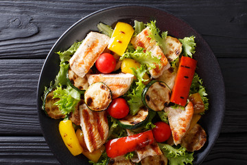 Salad with grilled chicken breast and summer vegetables closeup on table. horizontal top view
