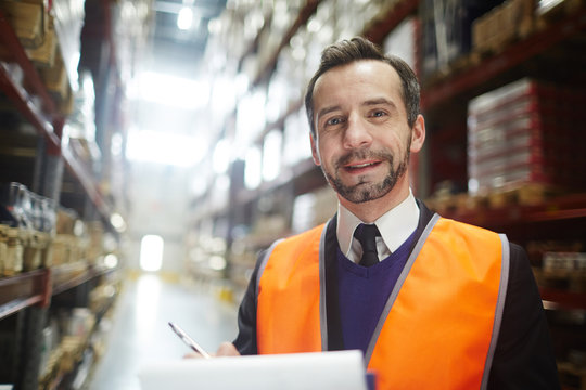 Wholesale Distributor Looking At Camera Inside Storehouse