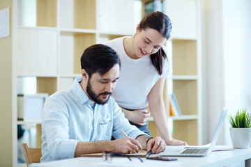 Portrait of modern man and woman dressed in casual clothes collaborating of project  in office