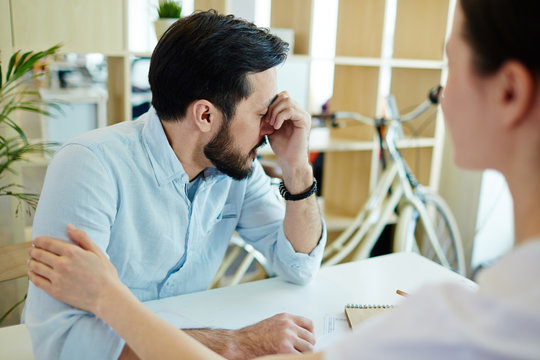 Portrait Of Sad Adult Man Turning Away To Hide Crying And Woman Trying To Console Him