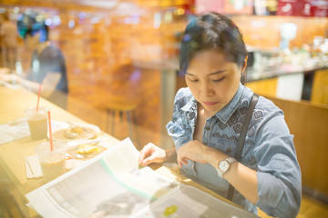 Asian woman reading magazine