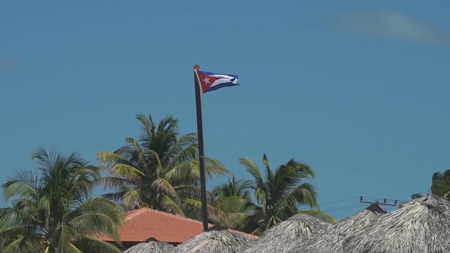 Cuban flag is fluttering on the wind in caribbean beach at summer sunny day