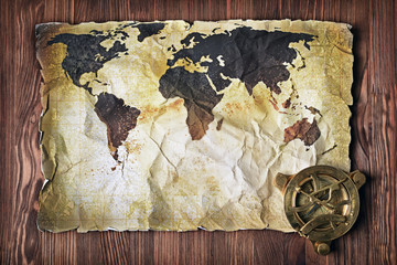 Old map of the world on yellow retro stained paper with vintage compass