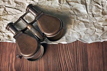 Close-up view of a vintage binoculars and an old paper sheet