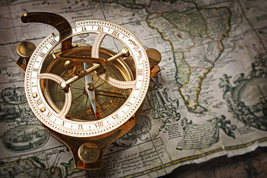 Close-up view of a vintage compass on an old retro map
