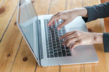 Fototapeta na wymiar Closeup of business woman hand typing on laptop keyboard .