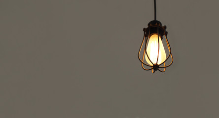 Isolated illuminated hanging light bulbs on grey plain background with free text space
