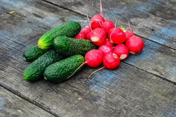Radish and cucumbers on wooden table