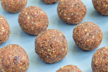Healthy homemade paleo energy balls with carrot, nuts, dates and coconut flakes, on tray, horizontal