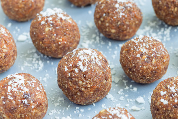 Healthy homemade paleo energy balls with carrot, nuts, dates and coconut flakes, on tray, horizontal