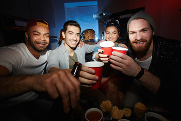 Toasting friends looking at camera at party