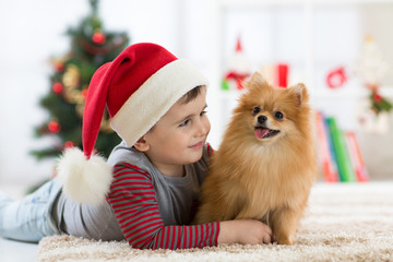 Happy kid little boy and dog at Christmas