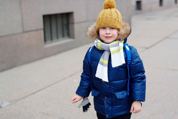 Adorable youngster in winterwear looking at camera