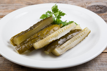 Canned cucumbers on a white plate