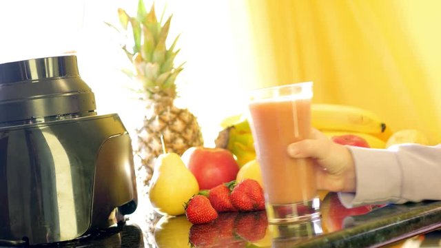 Footage of a morning routine, a table full of fresh fruits and a fresh mixed juice and a child's hand picking up the glass