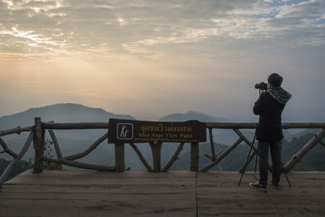 take a photo on the high mountain in the winter season morning time see the mist and sunrise in chiangmai , thailand