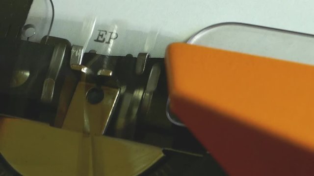 Extreme close up footage of a person writing EPILOGUE on an old typewriter...
