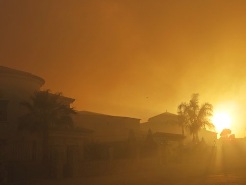 Casas rodeadas por mucho humo por incendio al atardecer / Houses surrounded by a lot of smoke by fire at dusk