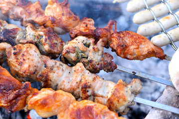 Grilling marinated shashlik on a grill. Shashlik is a form of Shish kebab popular in Eastern, Central Europe and other places. Shashlyk (meaning skewered meat) was originally made of lamb.
